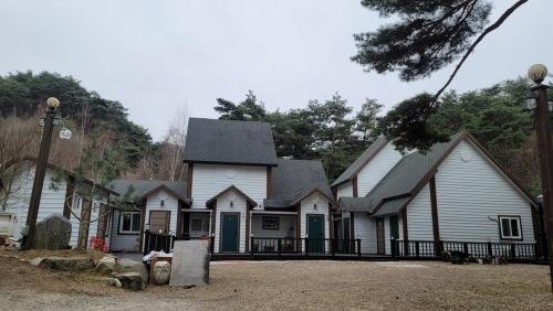 a large white house with a black roof at Namwon Along the Waterways of Jiri Mountain in Namwon