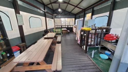 a room with benches and tables in a trailer at Namwon Along the Waterways of Jiri Mountain in Namwon