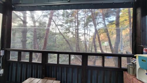 a window in a room with a view of a forest at Namwon Along the Waterways of Jiri Mountain in Namwon