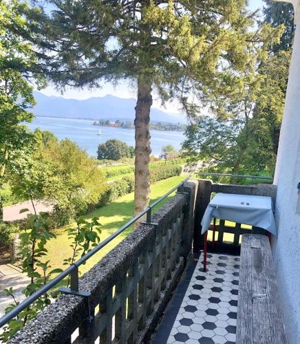 a table on a balcony with a view of the water at Ferienwohnung Villa Victoria mit grandiosem Seeblick und Gartennutzung in Jugendstil Villa in Gstadt am Chiemsee