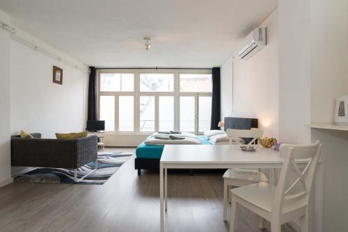 a living room with a bed and a table at RedLight District Private Smokers Friendly Studio in Amsterdam