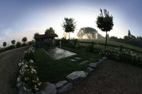 a garden with a pond in the middle of a road at Le Soleil in Vigone