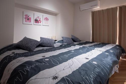 a bedroom with a bed with a blue and white comforter at Y's INN Nakano 016T in Tokyo
