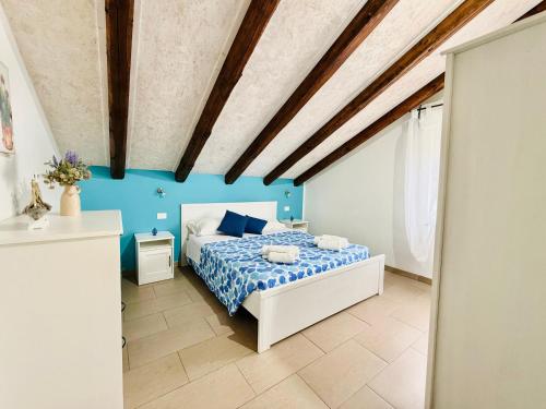 sypialnia z łóżkiem i niebieską ścianą w obiekcie San Lorenzo Holiday w mieście Reitani