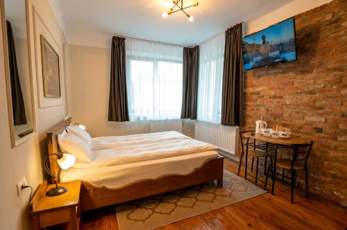 a bedroom with a bed and a brick wall at Stradela in Sighişoara