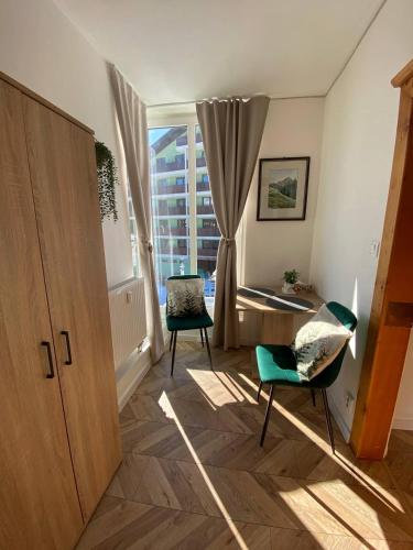 a living room with two chairs and a window at Apartmán DEJA VÚ - Tatranská Štrba in Štrba