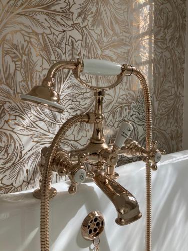 a bath tub with a faucet and a sink at Chambres d'hôtes La Massonnière avec grand jardin - idéal familles, groupes et séjour nature - Sarthe in Saint-Christophe-en-Champagne