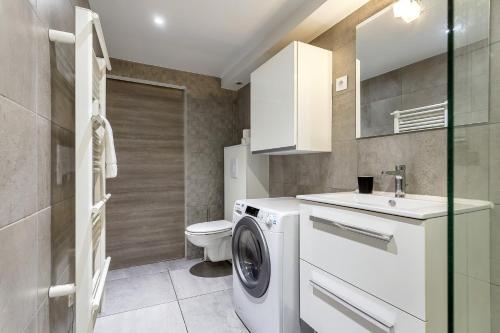 une salle de bain avec une machine à laver et un lavabo dans l'établissement Smartstay Louis Mille - Gratte-Ciel, à Villeurbanne