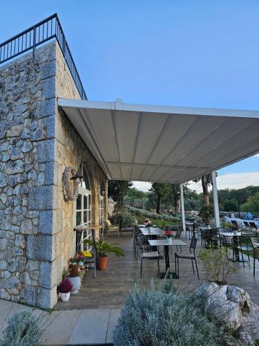 a patio with tables and chairs and a stone wall at Boutique Resort OSMA - Adults Only in Malinska