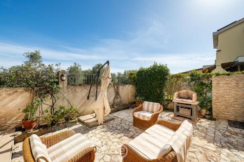 un patio con sedie e un camino in un cortile posteriore di Casa Daniela a Pula