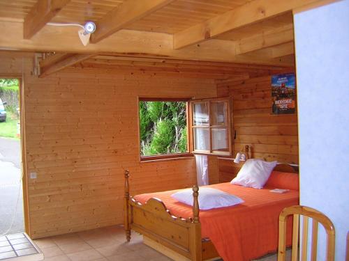 a bedroom with a bed in a log cabin at Gîte-Duplex La K-Bane 3 impasse des jardins Piscine et Jacuzzi à 500m in Saint-Flour