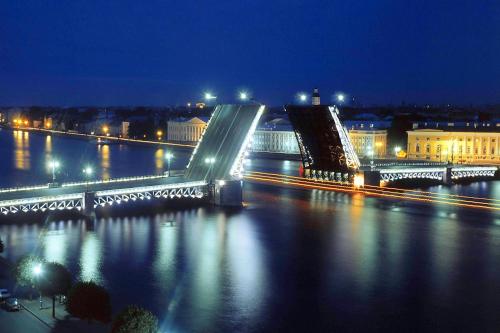 a bridge over a river at night with lights at Bonjour Hotel in Saint Petersburg