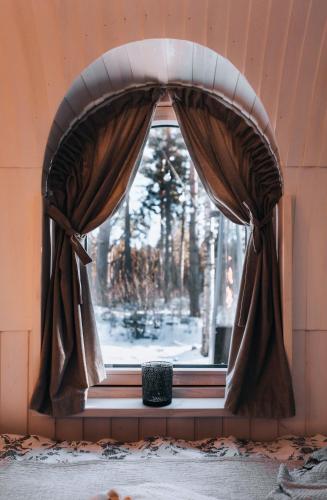 a window with curtains and a vase in a room at Pedaspä Igloo House and Sauna in Pedaspea