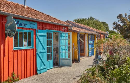 a row of colourful houses with their doors open at Résidence Odalys Terre Marine in Saint-Pierre-dʼOléron