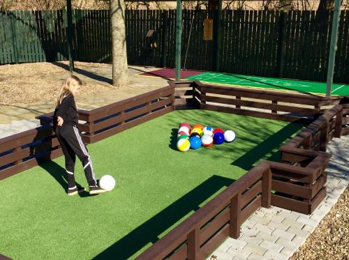a young woman walking on a artificial turf at Adventure Park Apartments in Ringkøbing