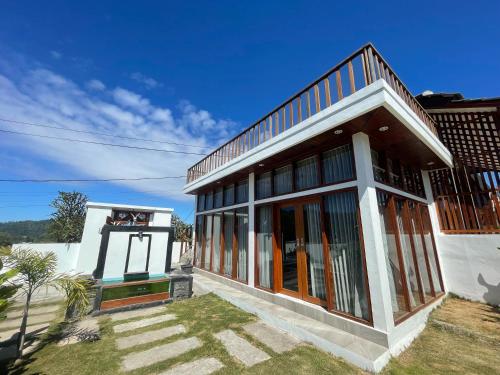 a white house with glass doors and a balcony at Volcano Side Kintamani Bali in Kintamani