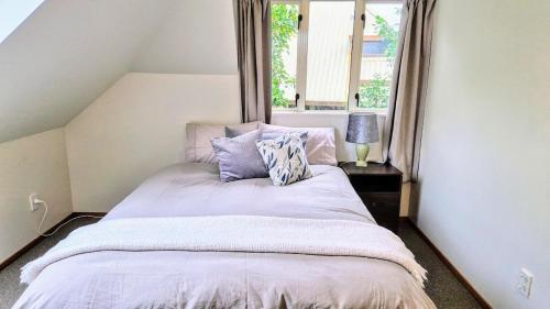 a bedroom with a bed with pillows and a window at Christchurch Home away from home in Christchurch