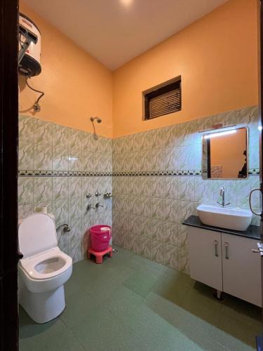 a bathroom with a toilet and a sink at Vacation home in Dharmsala