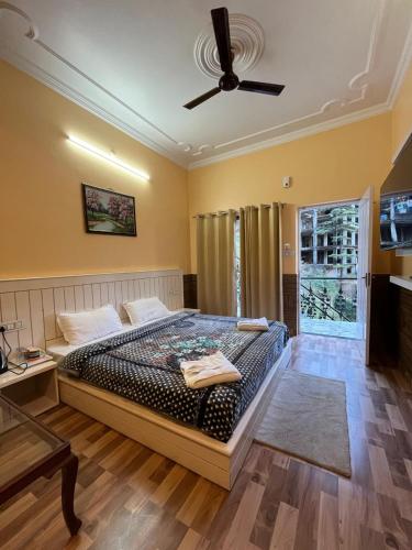 a bedroom with a bed and a ceiling fan at Vacation home in Dharmsala