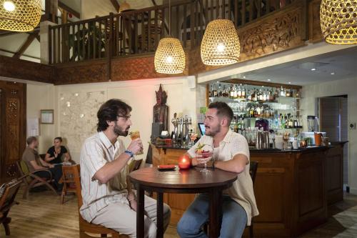two men sitting at a table in a bar with drinks at Les Jardins de Beauval in Saint-Aignan