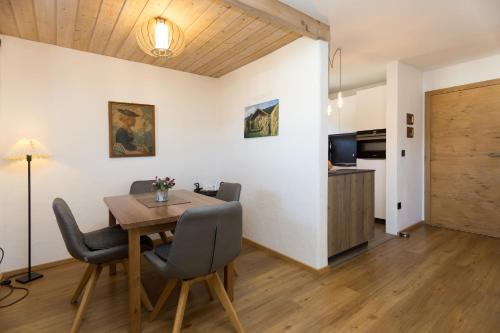 a dining room with a table and chairs and a kitchen at Ferienwohnung Mitteldorf in Oberammergau