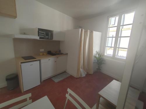 une cuisine avec un réfrigérateur blanc et une fenêtre dans l'établissement Studio cosy centre historique, à Arles