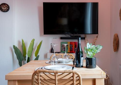 d'une table en bois avec une télévision. dans l'établissement L'Ecrin d'Albi - Love Room - 1 chambre, à Albi