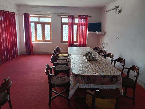 a dining room with a long table and chairs at Monal Inn in Mīlam