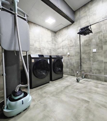 a laundry room with two washing machines in it at Cachet Boutique Kunming Artime 昆明彩云里凯世精品酒店 in Kunming