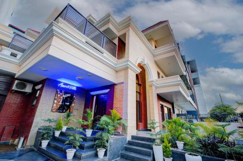 a house with stairs and potted plants in front of it at Amrit Hotel - Hotel & Banquet,Sector 32 in Gurgaon