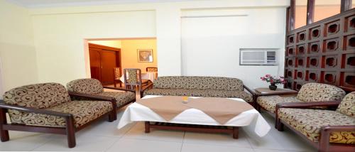 a living room with couches and a table at Blue Jay Tourist Complex in Samālkha