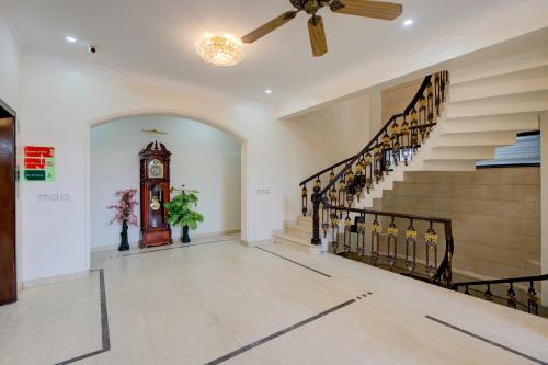 a hallway with a clock and stairs in a house at Amrit Hotel - Hotel & Banquet,Sector 32 in Gurgaon