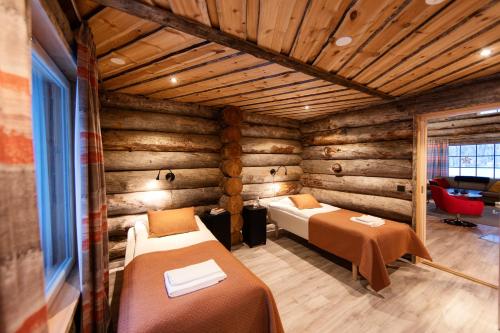 una camera con 2 letti in una baita di tronchi di Rukan Salonki Resort a Ruka