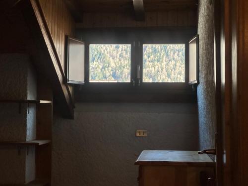 a room with a large window in a house at Rifugio del Sole Apartment in Monclassico