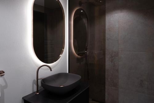 a bathroom with a black sink and two mirrors at Park Lane Copenhagen in Hellerup
