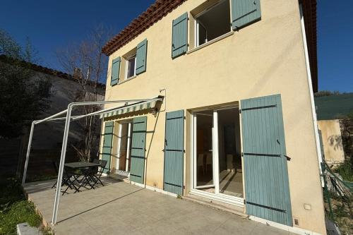 - un bâtiment avec des portes bleues et une terrasse dans l'établissement Pretty 7-people house 5 min from Opio Golf Club, à Valbonne