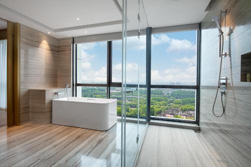 a bathroom with a white tub and a large window at Wyndham Shanghai Pudong in Shanghai