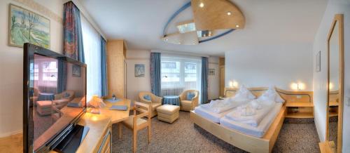 En eller flere senge i et værelse på Hotel Alpenhof