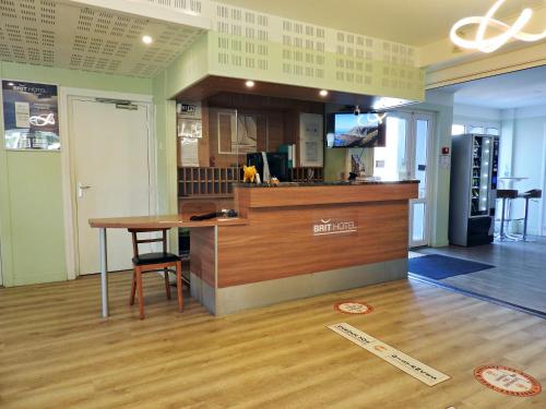 a kitchen with a counter and a table in a room at BRIT HOTEL Le 940 Le Touquet-Etaples in Étaples
