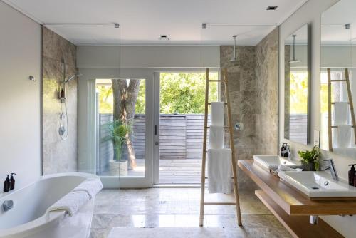 a bathroom with a tub and a shower and a sink at Angala in Simondium