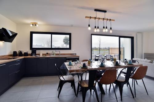 une salle à manger et une cuisine avec une table et des chaises dans l'établissement Ker Mada - 2 km de la plage, à Saint-Cast-le-Guildo