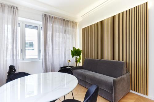 a living room with a couch and a table at Duomo Imperial Suits - Modern and comfortable in Milan