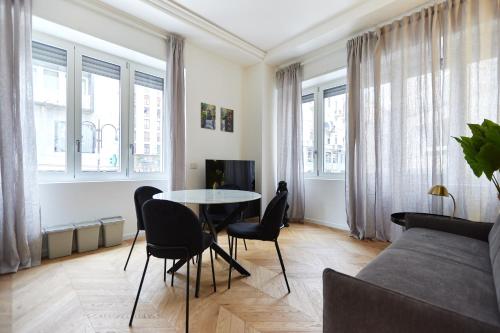a living room with a table and chairs and a couch at Duomo Imperial Suits - Modern and comfortable in Milan