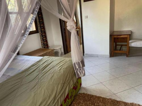 a bedroom with a bed with a canopy at Guest room 1, A home away from home in Kampala