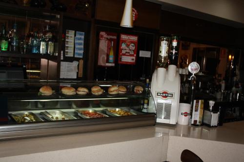a bar with a counter with food and a cash register at Hotel Altiana in Ourense
