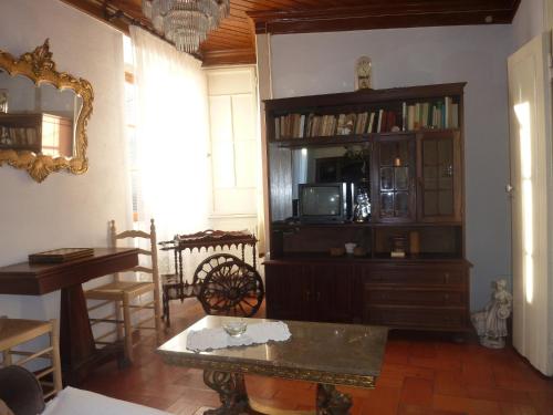 een woonkamer met een boekenplank en een tv bij Casa da Rosa in Póvoa de Rio de Moinhos