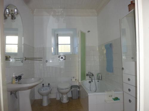 a bathroom with a sink and a toilet and a bath tub at Casa da Rosa in Póvoa de Rio de Moinhos