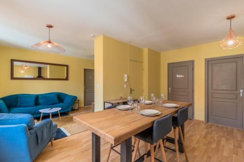 un salon avec une table et un canapé bleu dans l'établissement Appartement 2 chambres proche metro et parking, à Roubaix