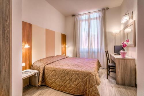 a hotel room with a bed and a desk at Hotel Arno Bellariva in Florence