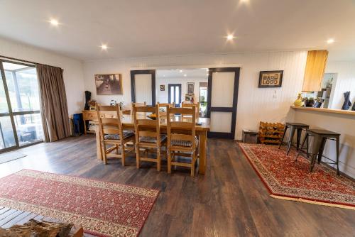 a dining room and living room with a table and chairs at Southern Lights Retreat - Main House in Dunedin